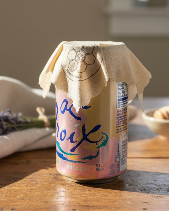 Can of La Croix with a Beeusable Beeswax Wrap covering the opening on a wooden surface