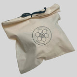 A beige cotton drawstring bag with a black logo printed on the front reading 'BEEUSABLES' and 'Made in Oregon', photographed on a white surface.