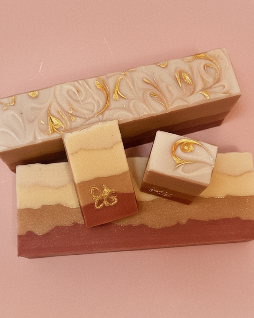 Three layered soap bars with decorative designs on a pink background